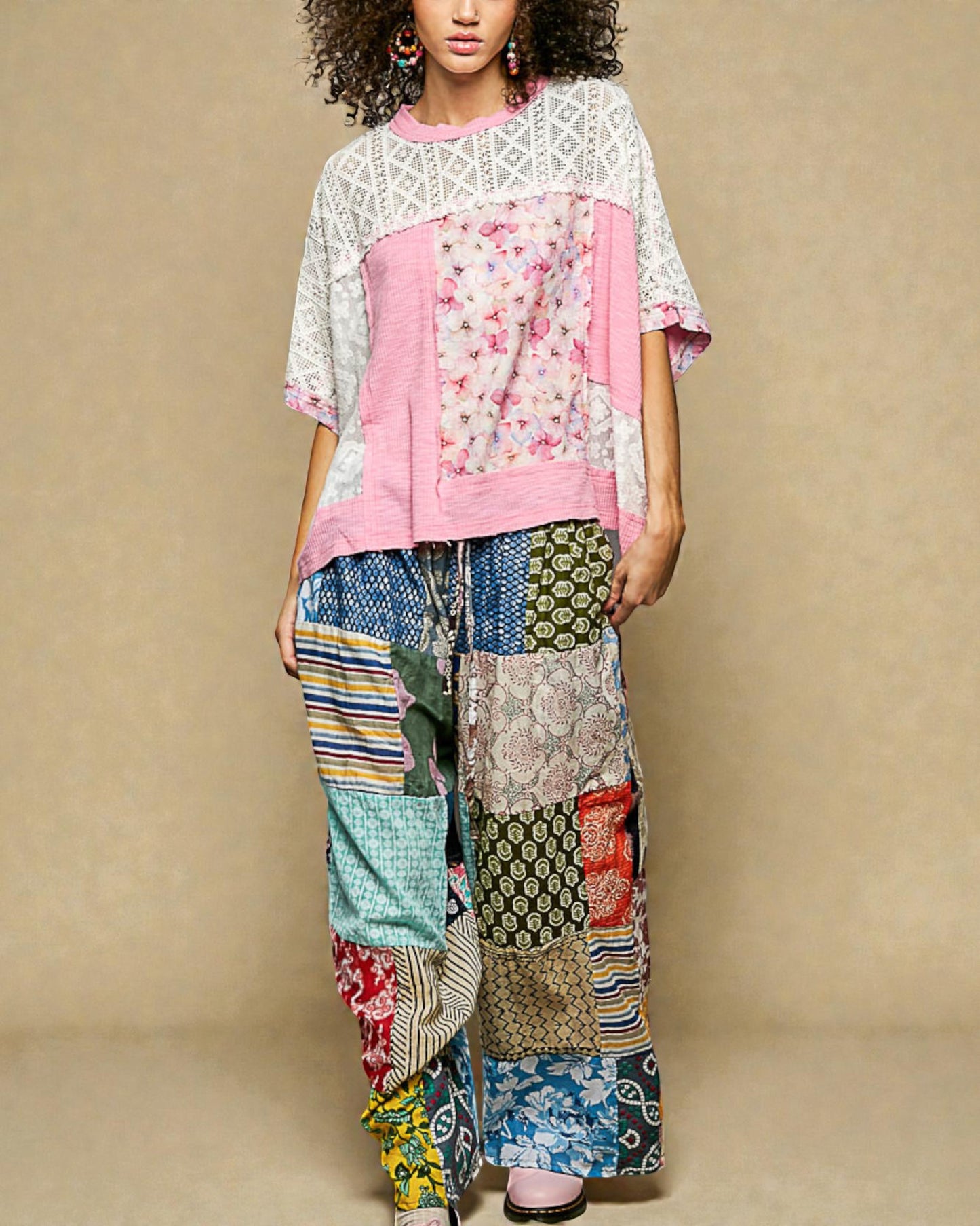 Person wearing a colorful patchwork outfit with a plain background