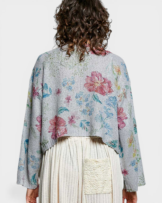 Person wearing a floral-patterned cardigan on a white background