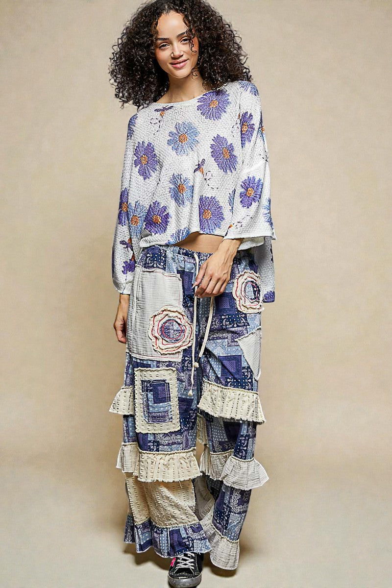 Woman wearing a floral top and patchwork skirt on a beige background