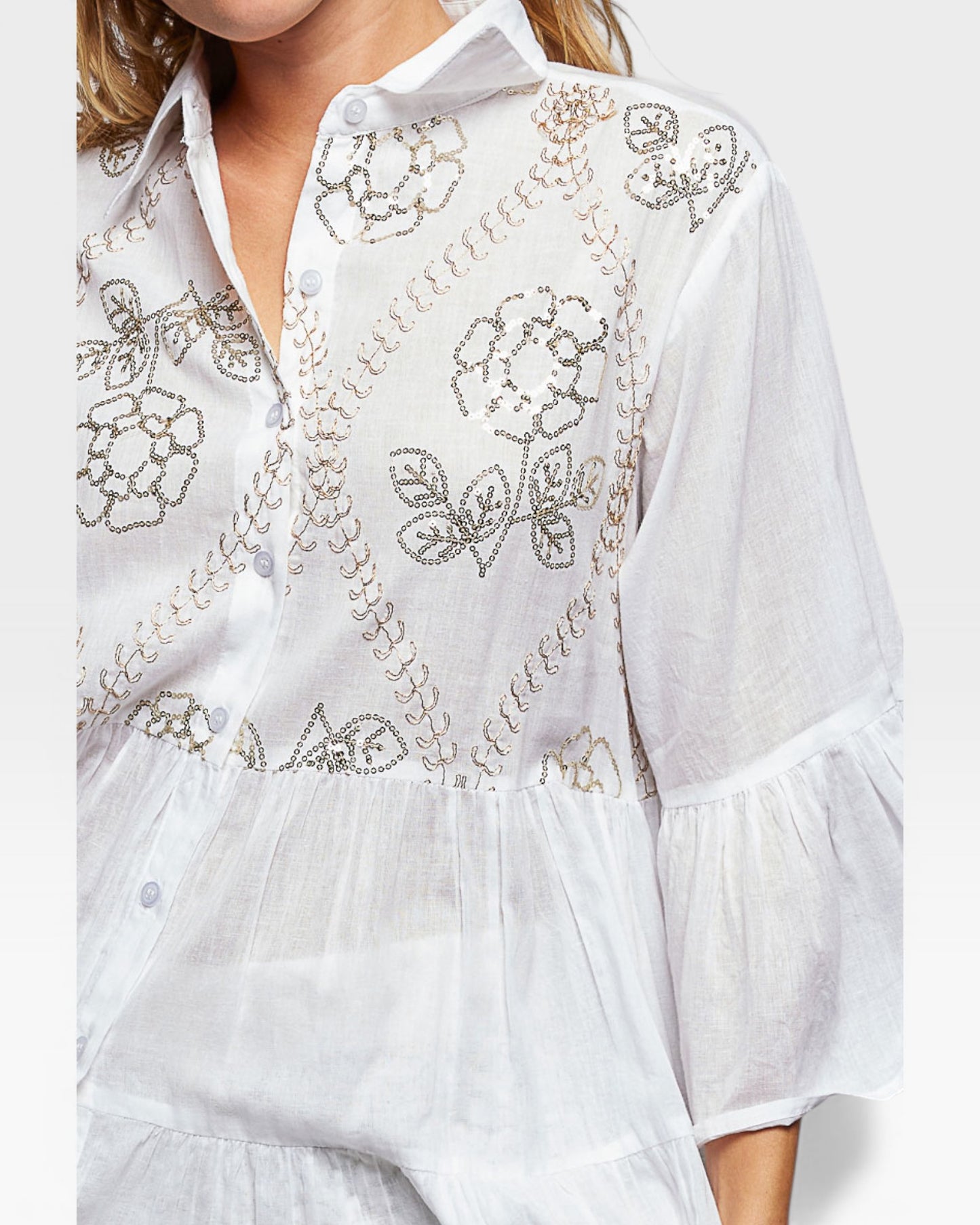 White embroidered dress with floral patterns on a white background