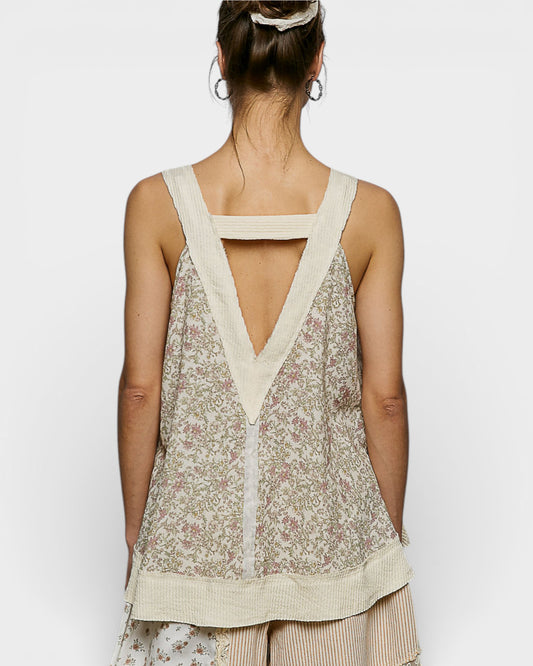 Woman wearing a floral sleeveless top with a V-neckline on a white background
