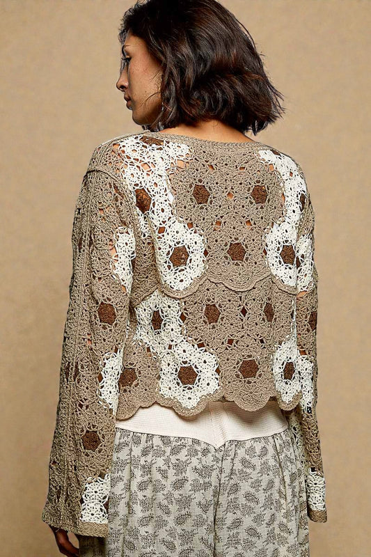 Woman wearing a beige and brown patterned top against a beige background