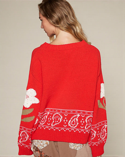 Red sweater with white patterns on a beige background