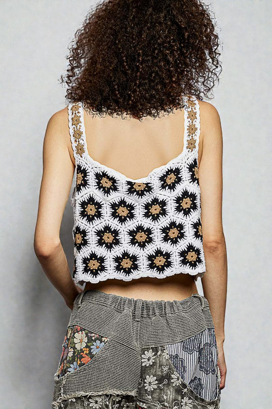 Person wearing a patterned sleeveless top with a plain background