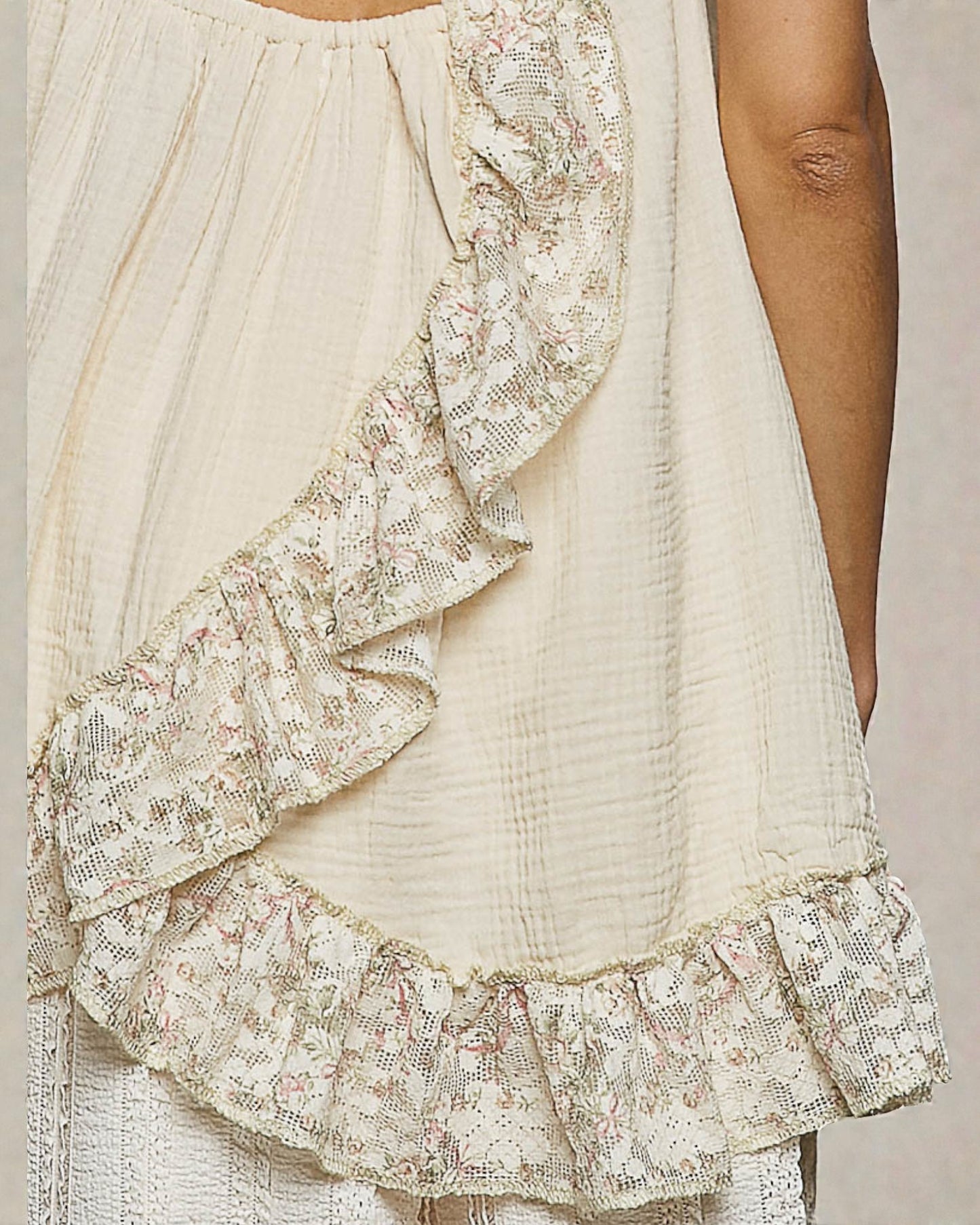 Beige dress with floral lace details on a neutral background