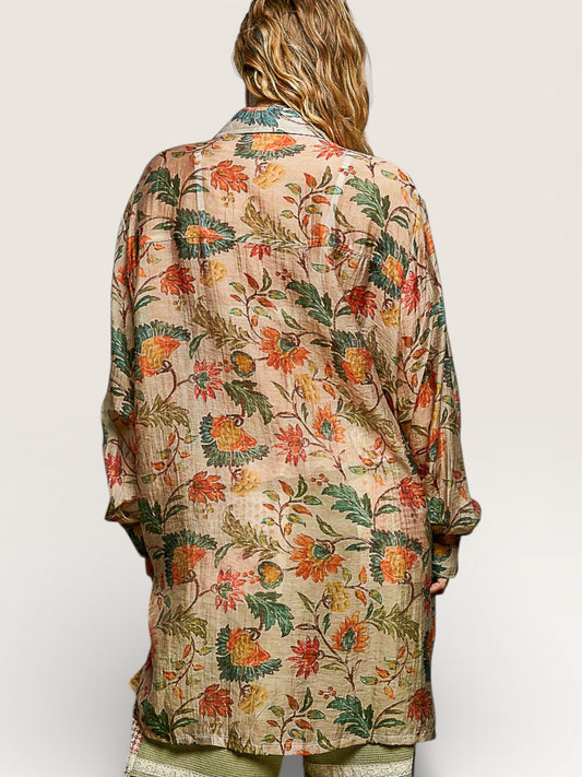 Floral patterned shirt worn by a person on a plain background