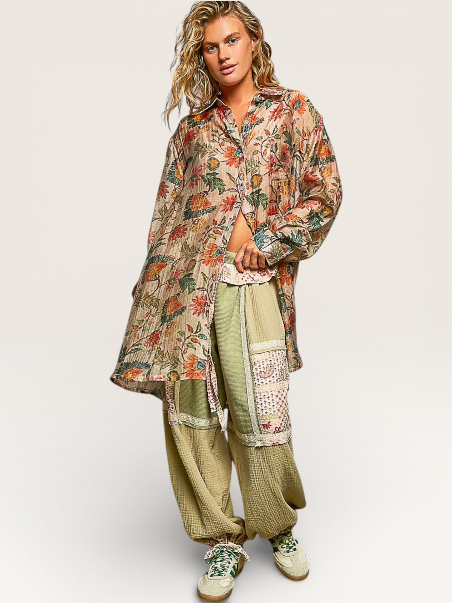 Person wearing a floral shirt and green pants on a white background