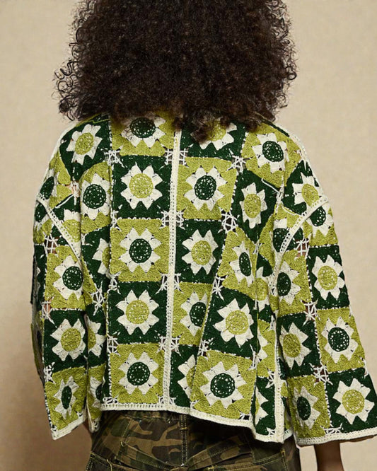 Person wearing a green and white patterned jacket with a beige background