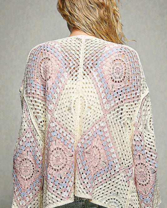 Crocheted cardigan with a colorful pattern on a gray background