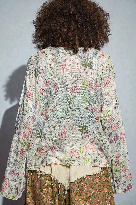 Person wearing a floral blouse with a plain background