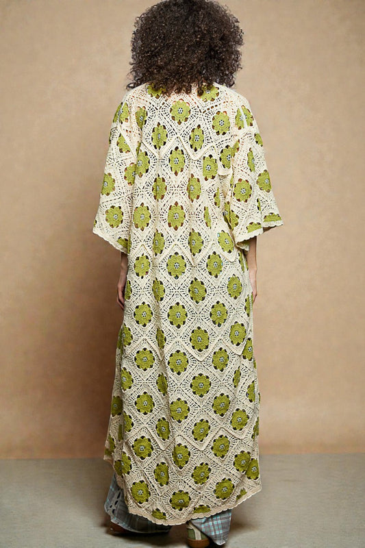 Person wearing a green and white floral crochet dress against a beige background