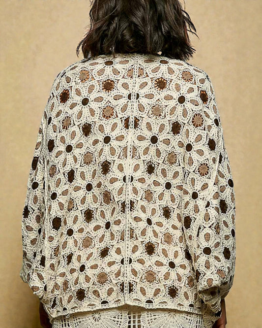 Person wearing a patterned jacket against a beige background