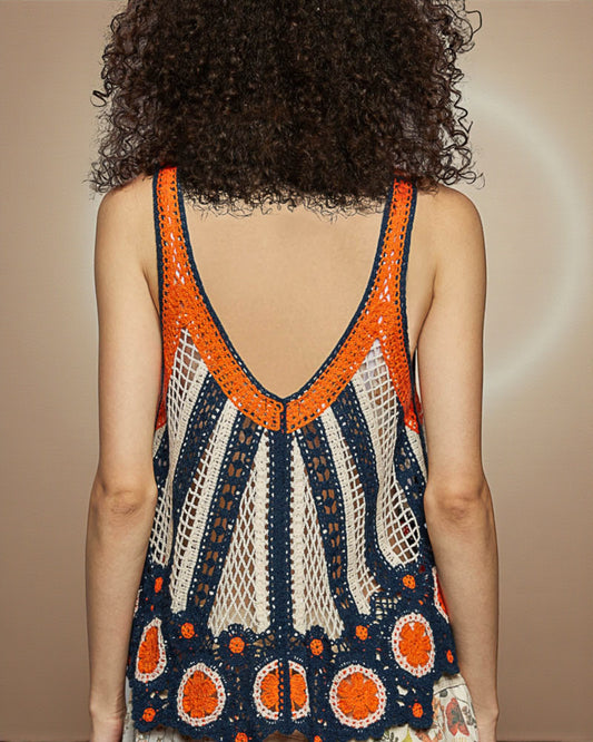 Person wearing a colorful crochet dress with an open back on a beige background