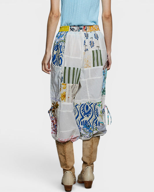 Person wearing a colorful patchwork skirt on a white background