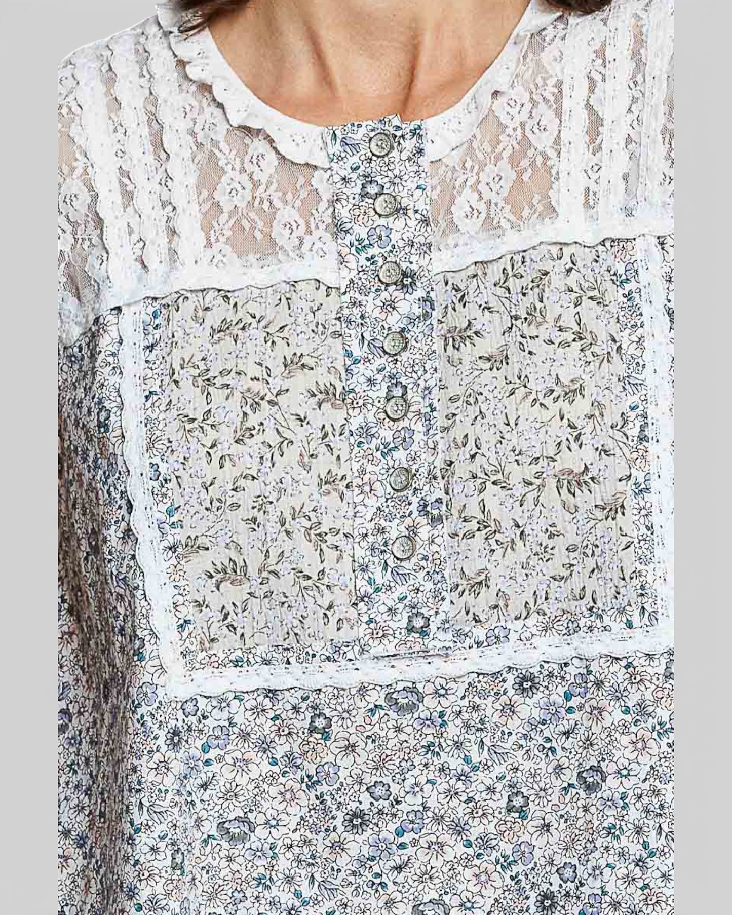 Close-up of a floral dress with lace details on a gray background