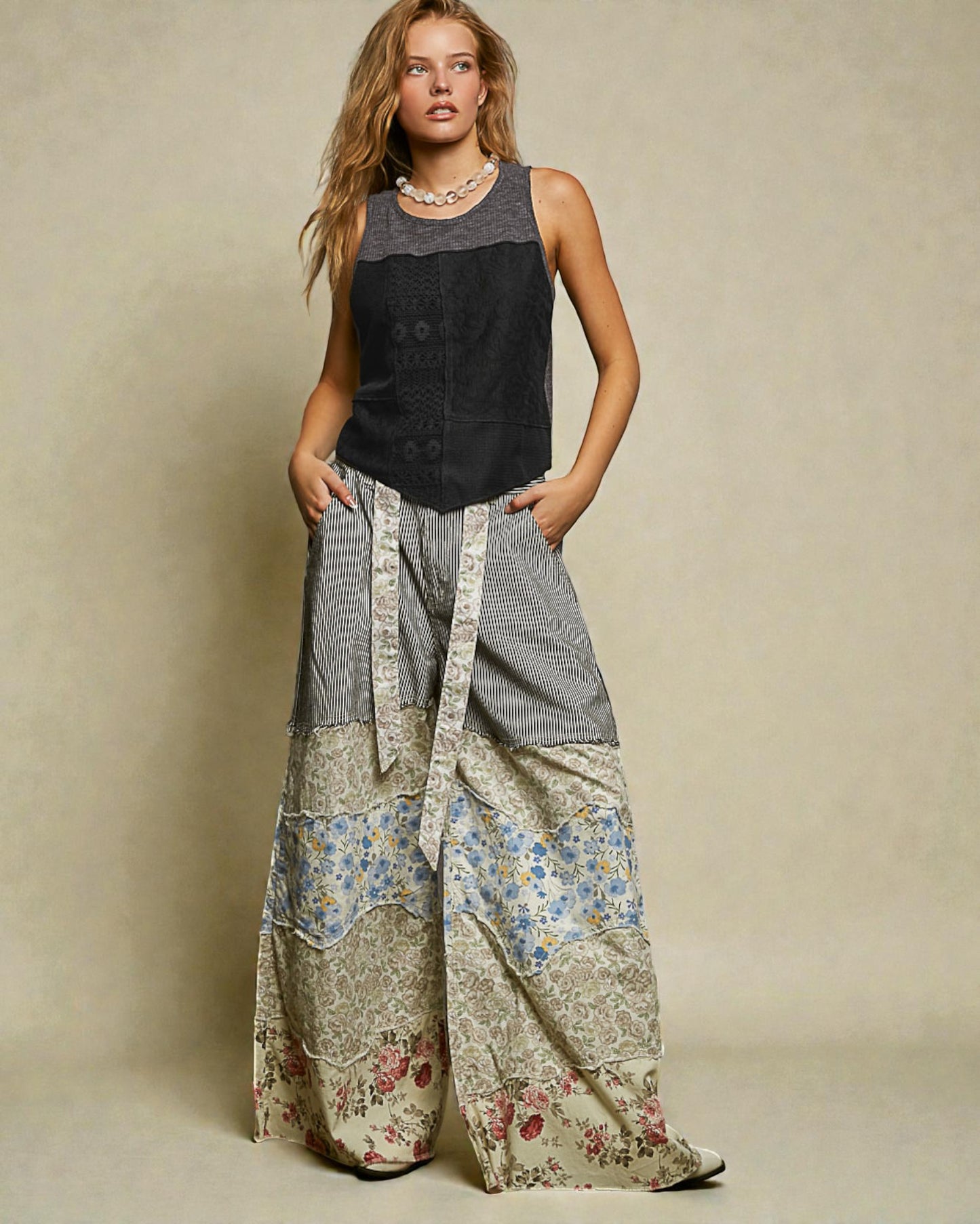 Woman wearing a sleeveless top and patterned wide-leg pants against a beige background