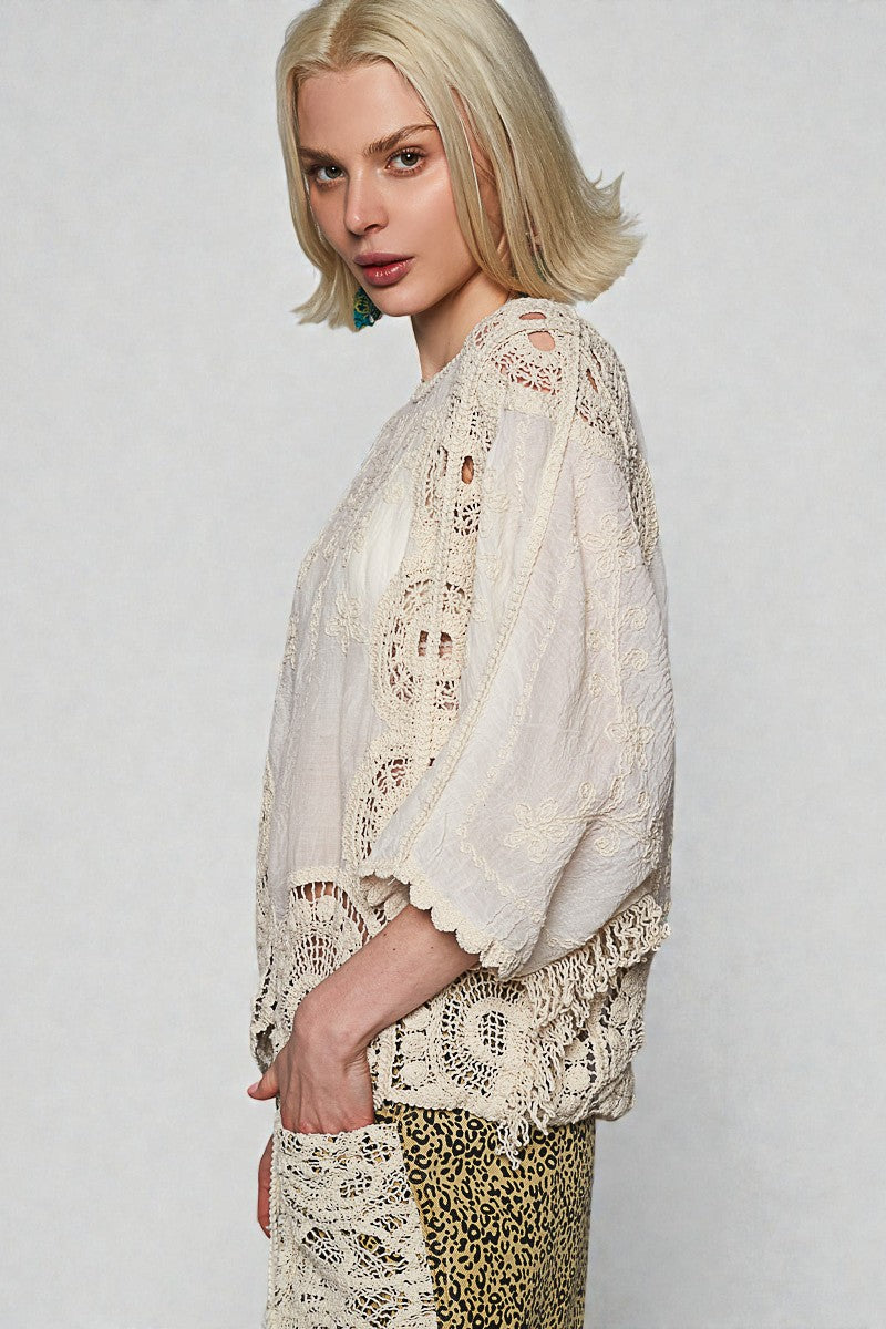 Woman wearing a lace top and leopard print pants against a plain background