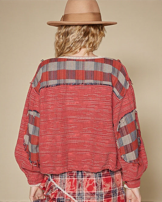 Person wearing a red plaid shirt and hat on a beige background