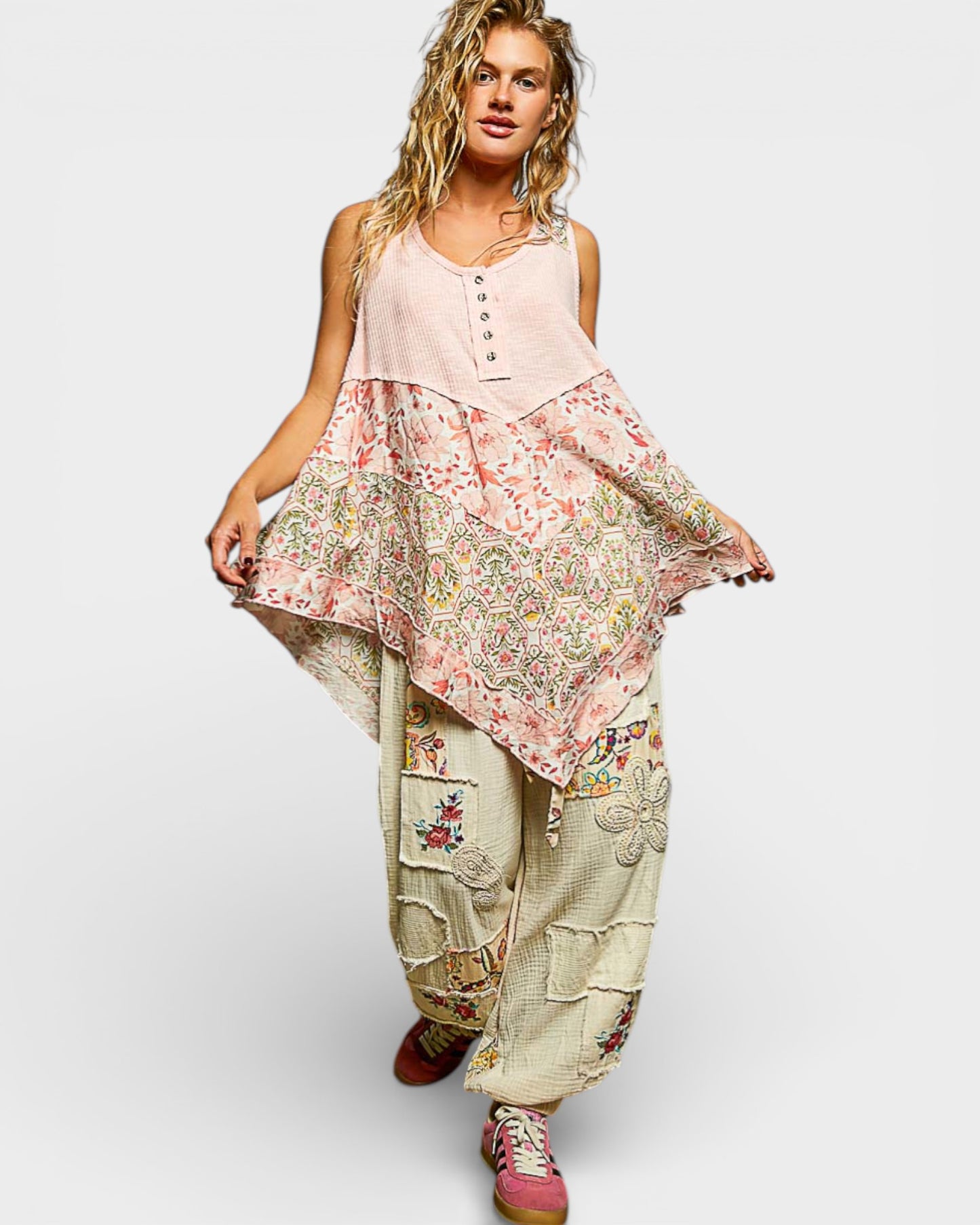 Woman wearing a floral top and baggy pants on a white background