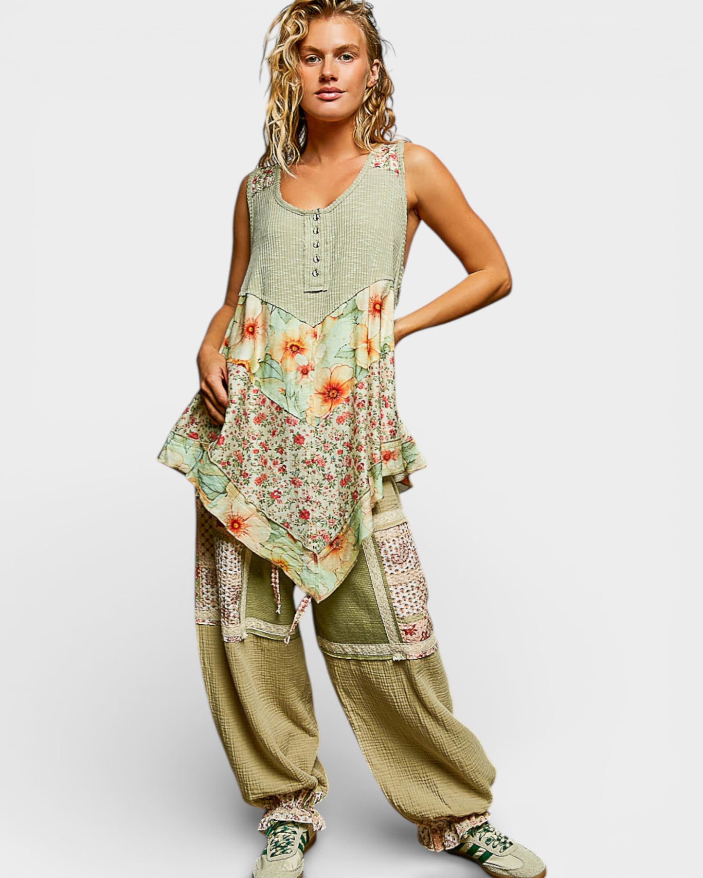 Woman wearing a floral top and wide-leg pants on a white background