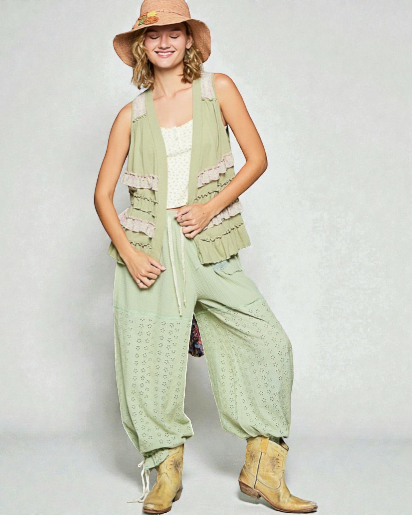 Woman wearing a light green outfit with a hat on a white background