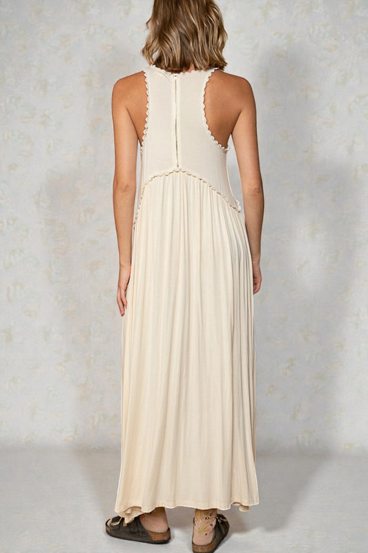 Woman wearing a beige sleeveless dress against a light background