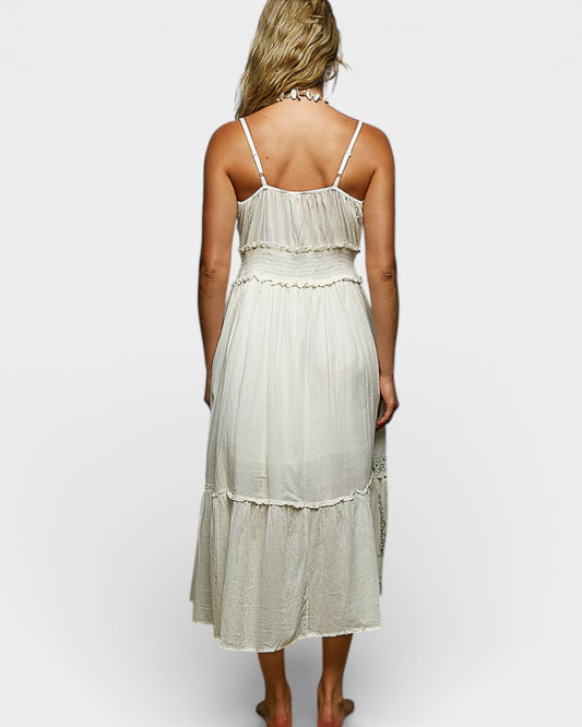 Woman wearing a light-colored dress with thin straps on a white background