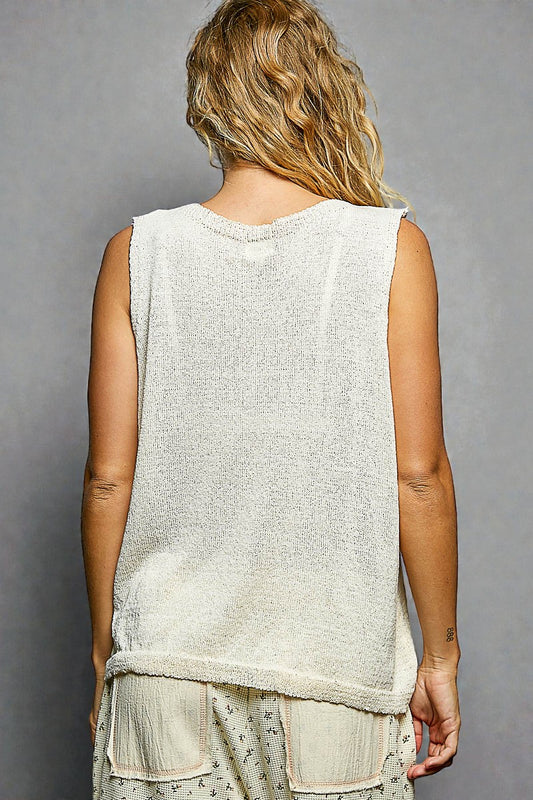 Person wearing a sleeveless top with a gray background