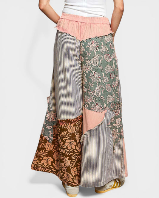 Person wearing a patchwork skirt with floral, striped, and animal print patterns on a white background.