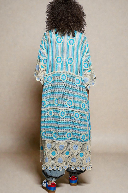 Person wearing a long, patterned dress with a neutral background