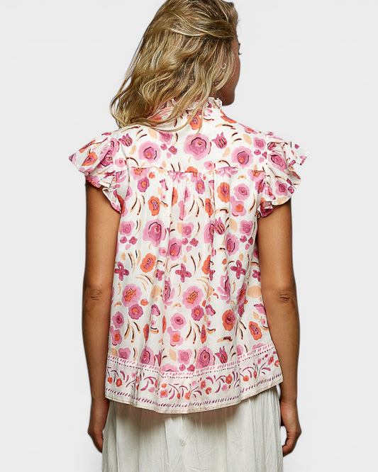 Woman wearing a floral blouse with a plain background