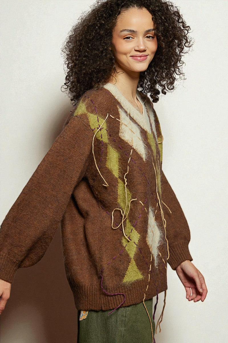 Woman wearing a patterned sweater against a plain background