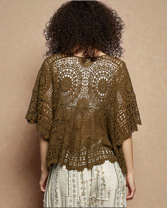 Woman wearing a brown crochet top against a beige background