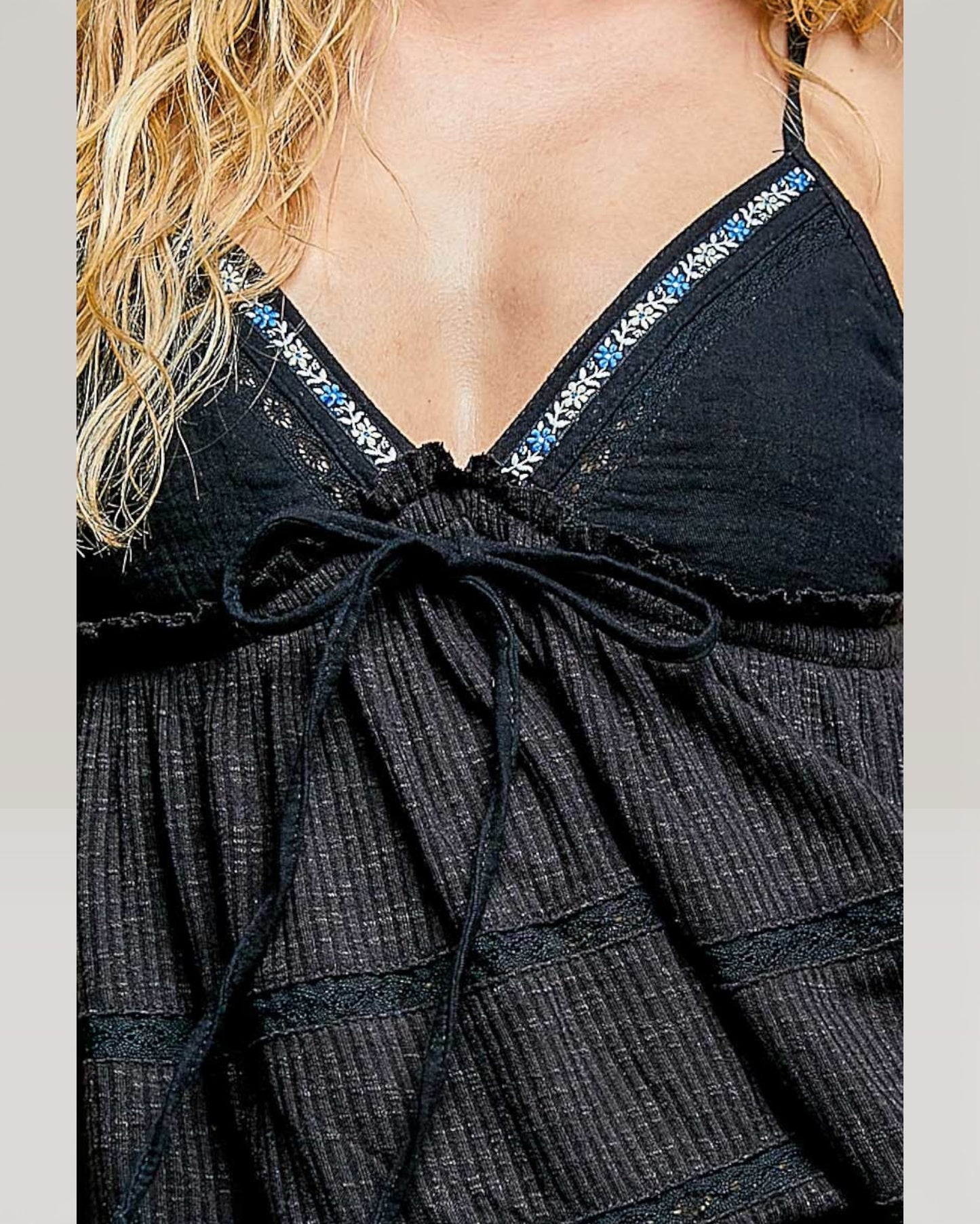Black dress with blue embellishments on a plain background