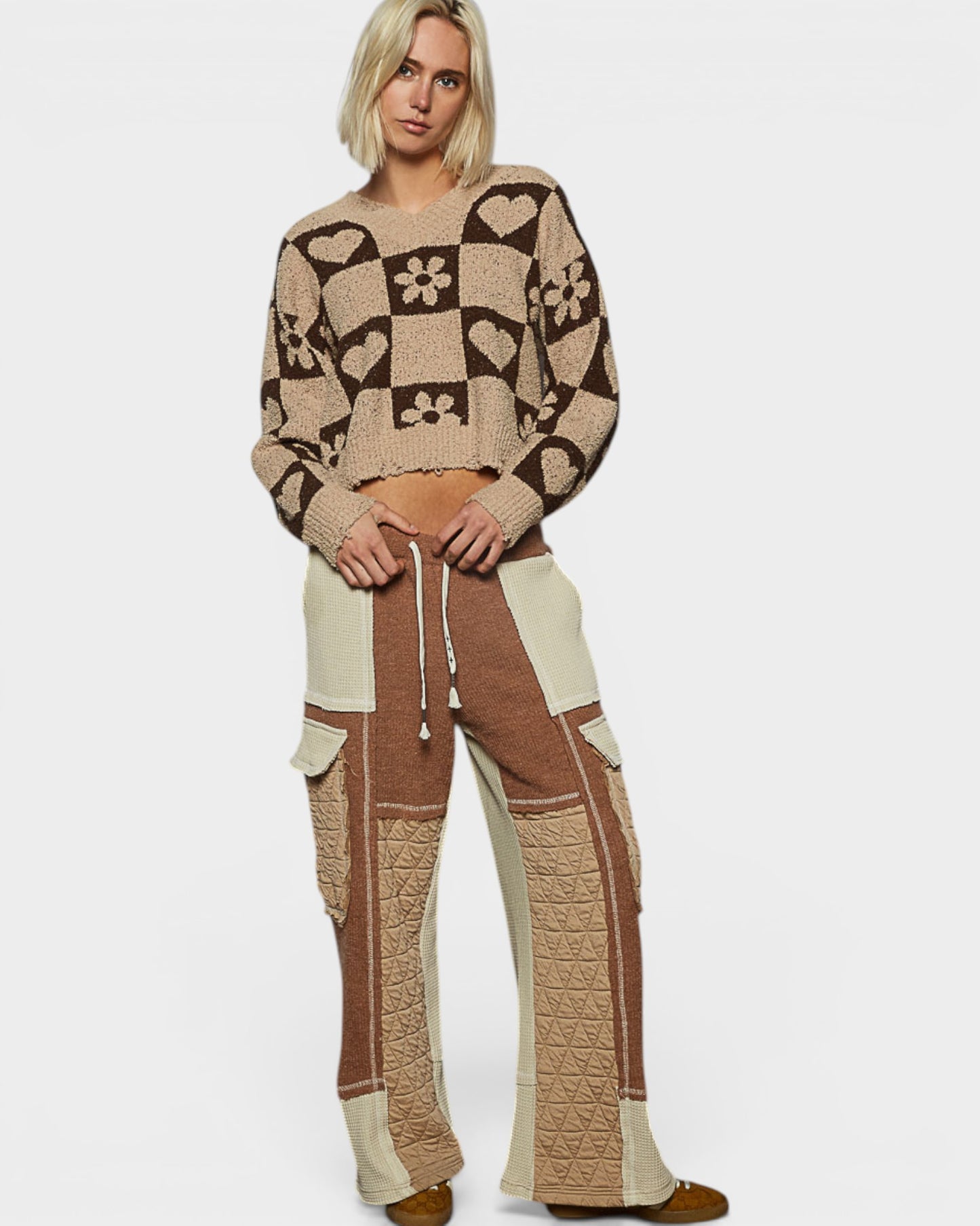 Woman wearing a patterned sweater and pants set on a white background