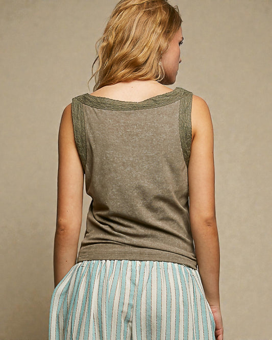 Woman wearing a green sleeveless top with a beige background