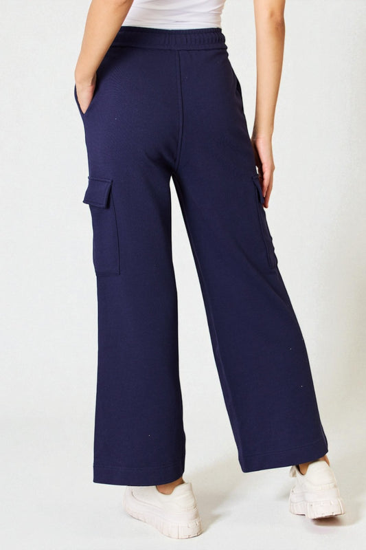 Navy cargo pants worn by a person on a white background