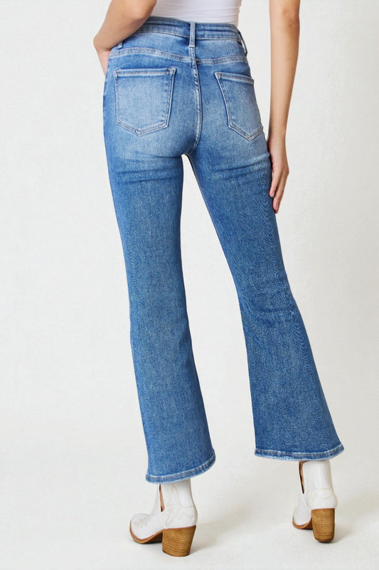 Blue jeans worn by a person on a white background