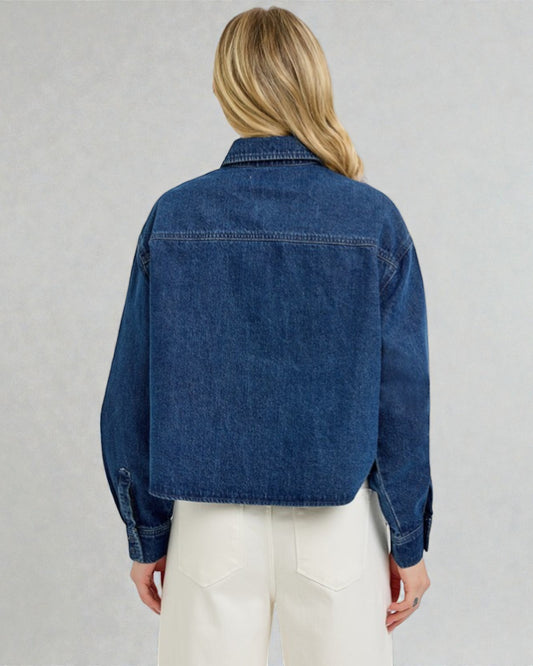 Person wearing a blue denim jacket on a plain background