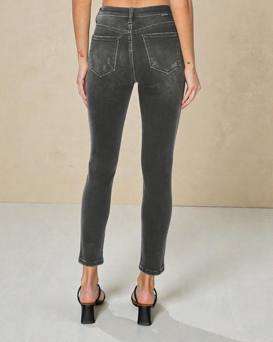 Person wearing black jeans on a neutral background