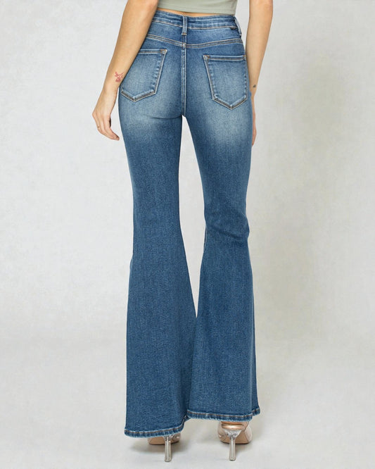 Flared jeans worn by a person on a plain background