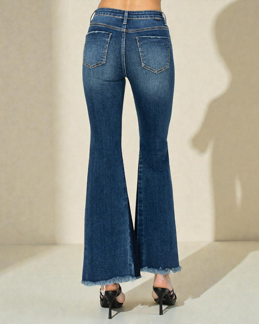 Blue flared jeans worn by a person on a neutral background