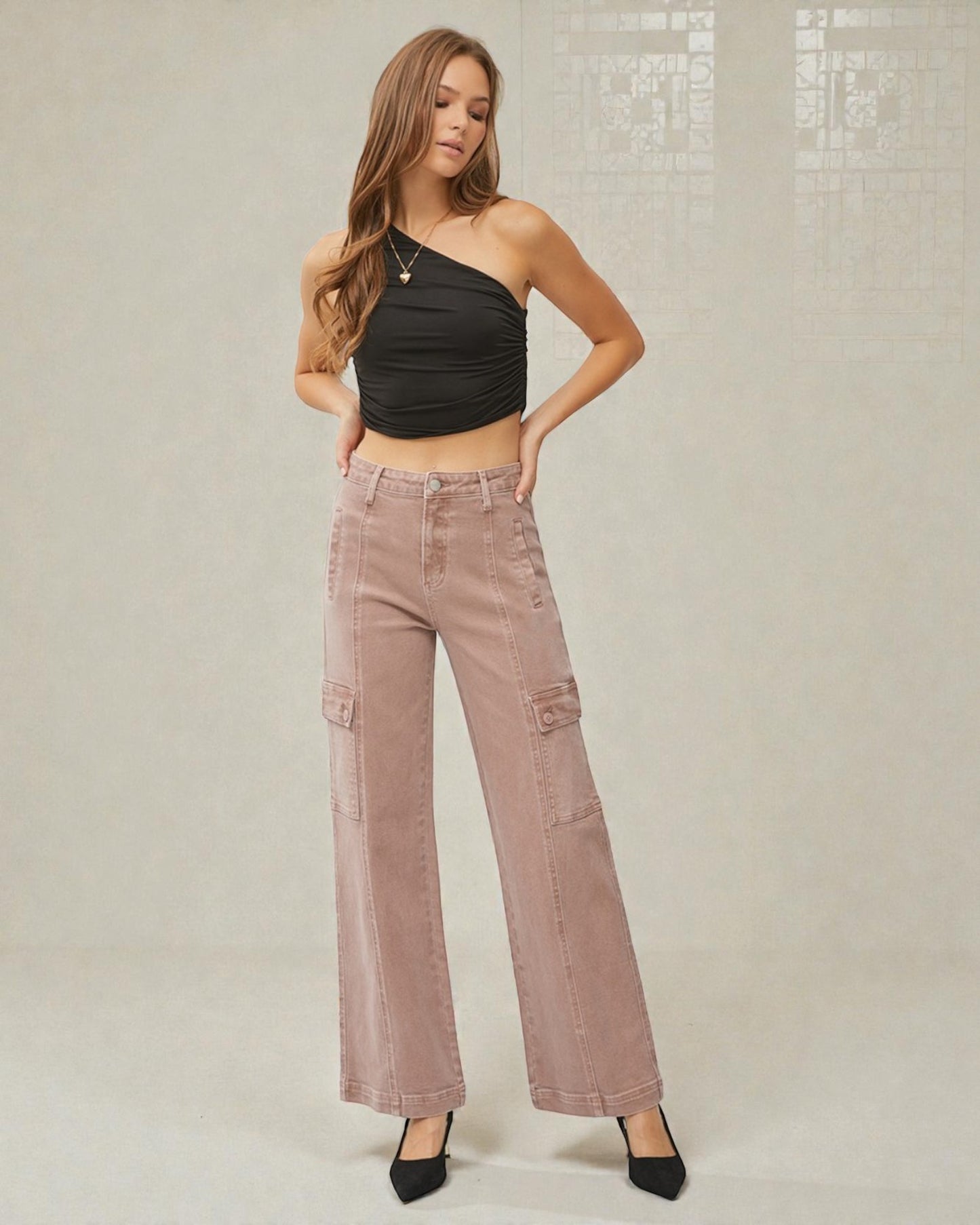 Woman wearing a black halter top and pink cargo pants against a neutral background