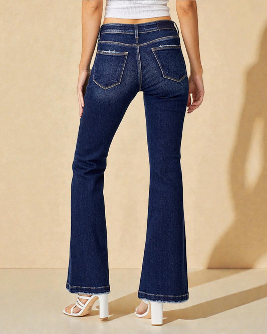 Person wearing blue flared jeans on a beige background