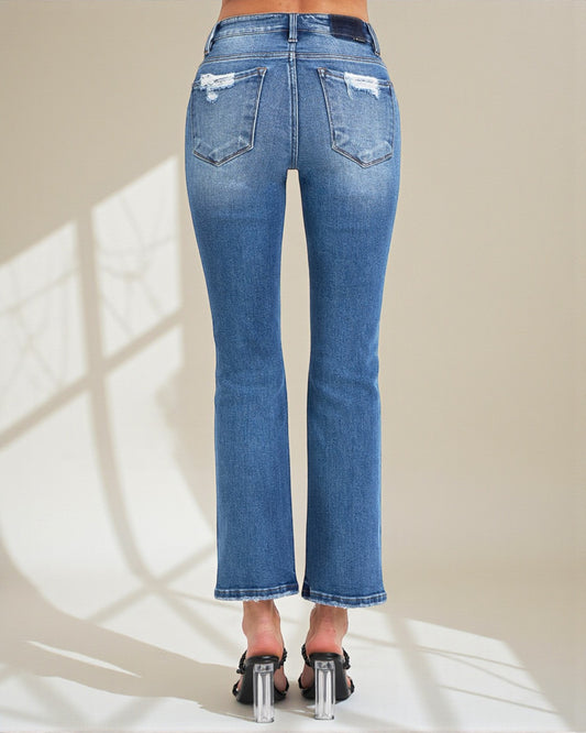 Blue jeans worn by a person on a neutral background