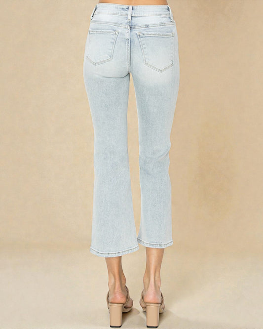 Light blue jeans worn by a person on a beige background