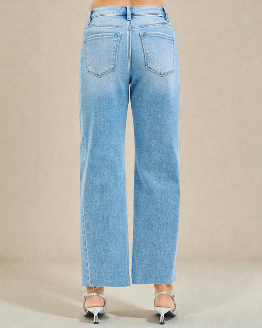 Light blue jeans worn by a person on a beige background