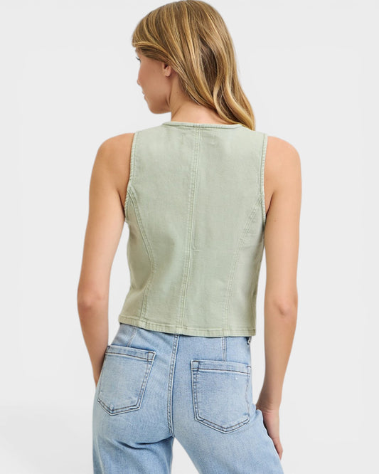 Person wearing a light green sleeveless top and blue jeans on a white background