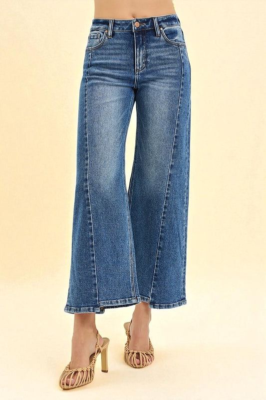 Blue jeans worn by a person on a beige background