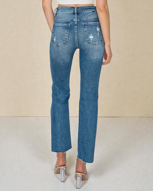 Blue jeans worn by a person on a plain background